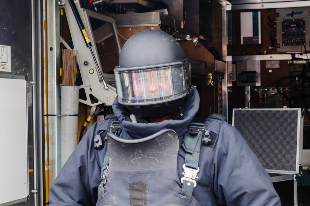 A man wearing a bomb-proof helmet with shield